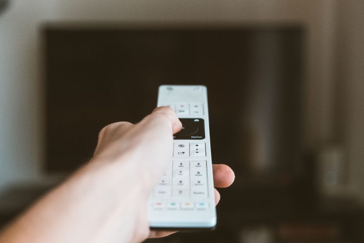 iemand gebruikt een afstandsbediening van de televisie van internet en tv met cadeau
